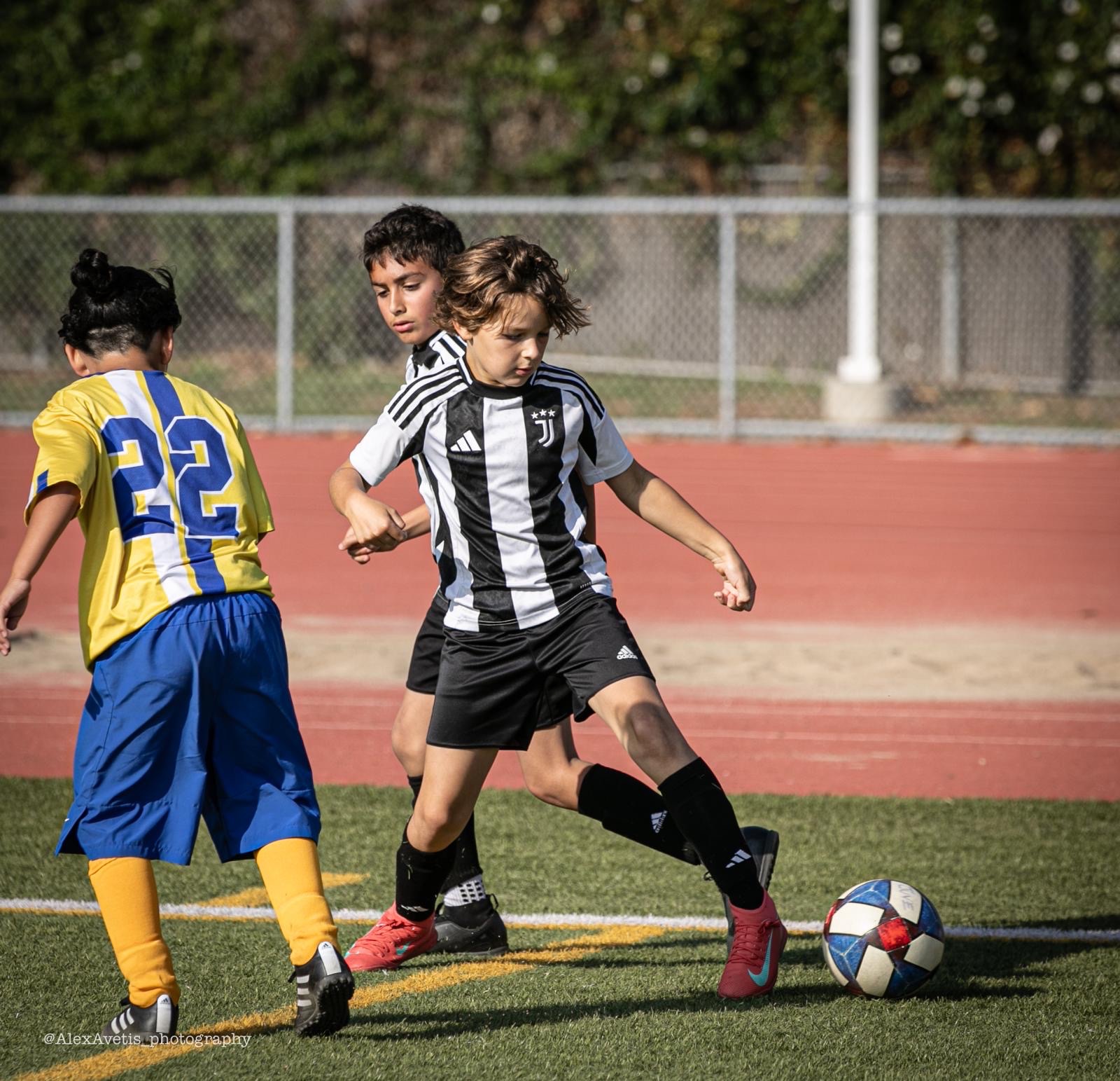 Juventus Academy Phoenix player dribbling past an opponent