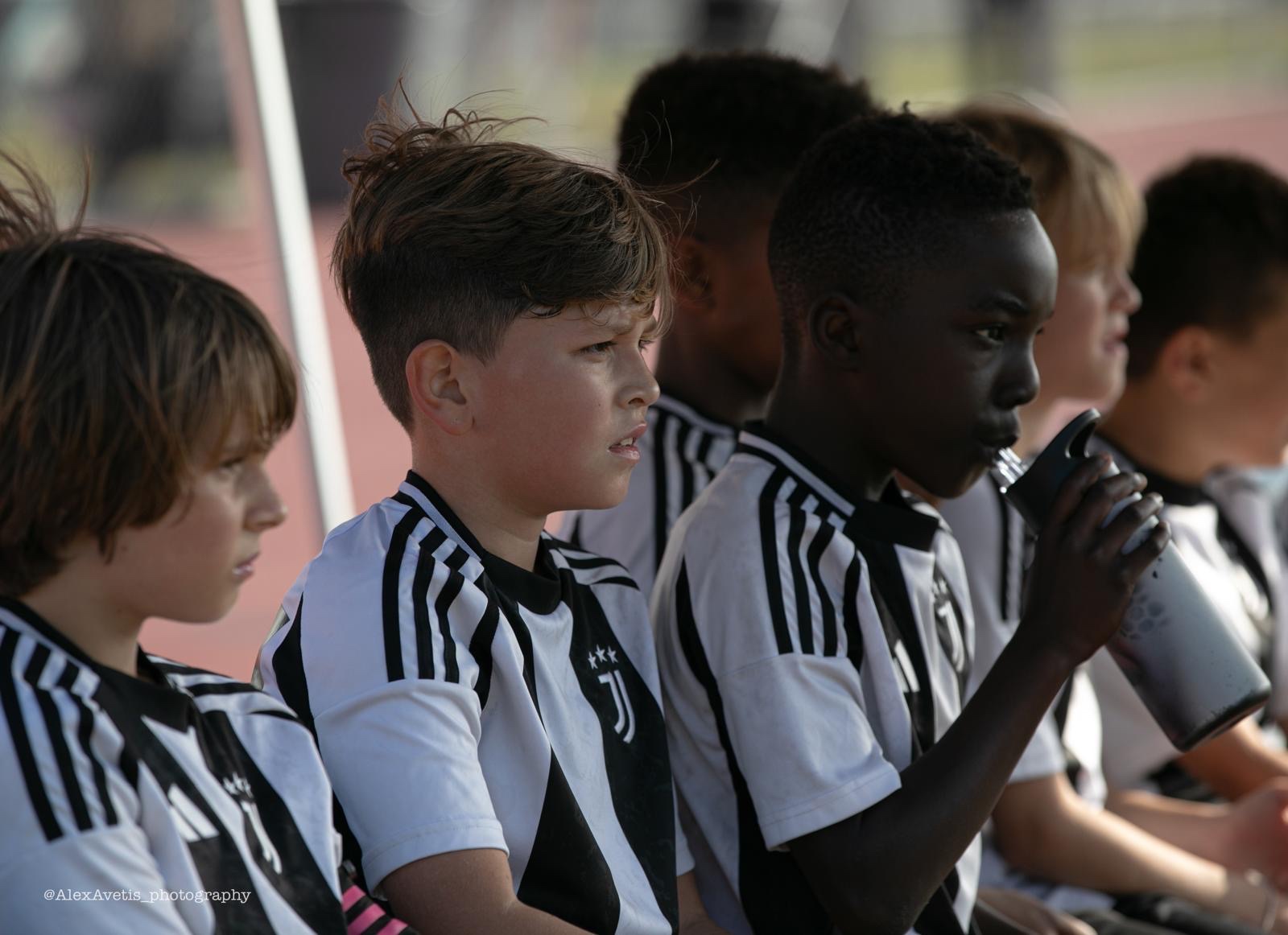 Juventus Academy Phoenix players watching the match from the sideline
